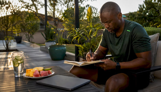 Man journaling about male vitality at home kitchen